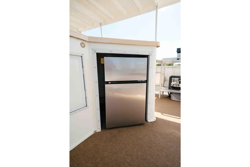  Yacht Photos Pics Stainless steel refrigerator on 2004 Stardust Cruisers houseboat deck, with beige carpet flooring.