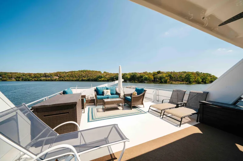  Yacht Photos Pics Luxurious 2004 Stardust Cruisers houseboat deck with seating, overlooking serene lake and lush greenery.