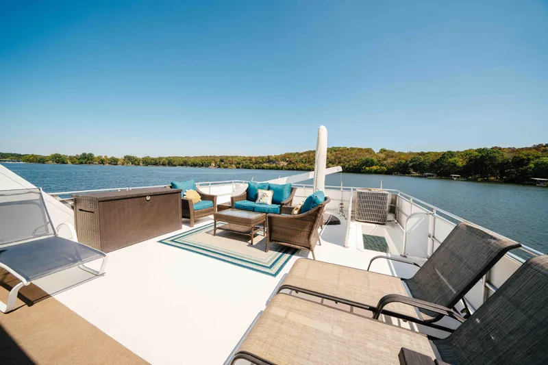  Yacht Photos Pics Luxurious 2004 Stardust Cruisers houseboat deck with seating, overlooking serene lake and lush shoreline.