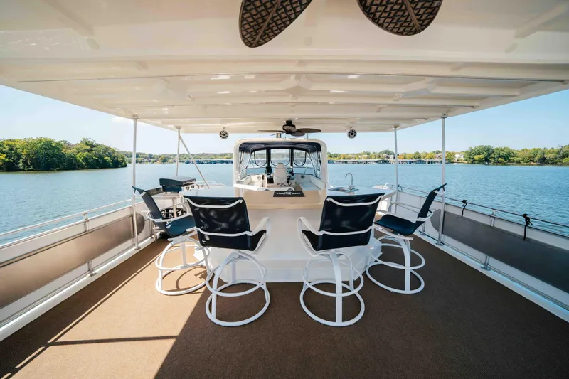  Yacht Photos Pics 2004 Stardust Cruisers houseboat with seating area on a serene lake.