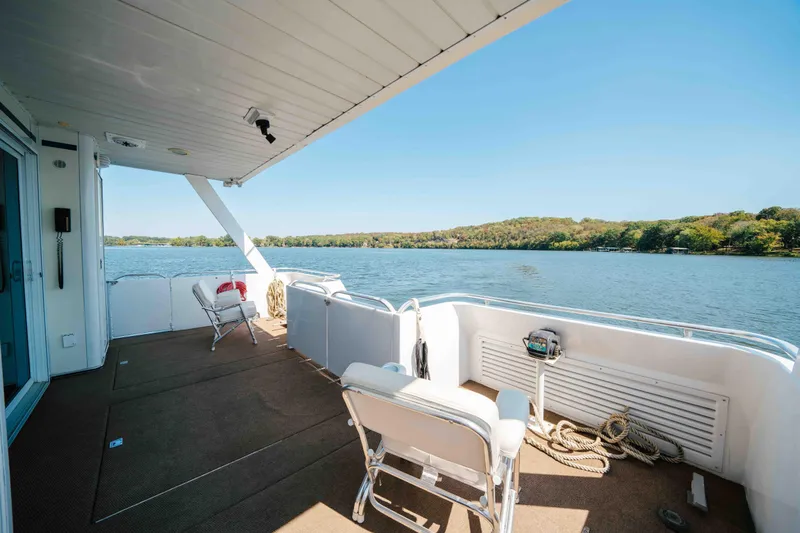  Yacht Photos Pics 2004 Stardust Cruisers houseboat deck with chairs, overlooking serene lake and lush shoreline.