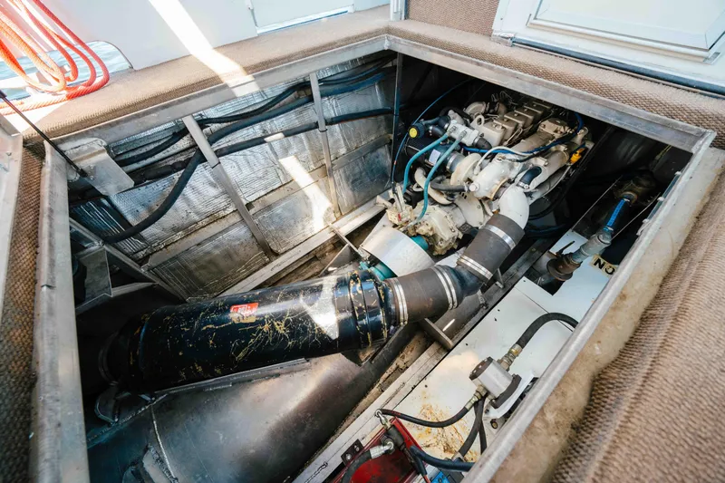  Yacht Photos Pics Engine compartment of a 2004 Stardust Cruisers houseboat, showcasing mechanical components and wiring.