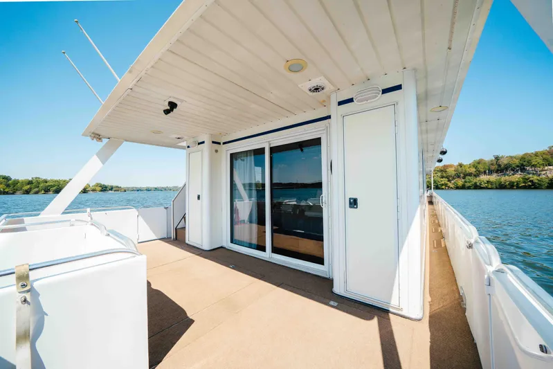  Yacht Photos Pics 2004 Stardust Cruisers houseboat deck with sliding doors, overlooking serene lake and lush shoreline.