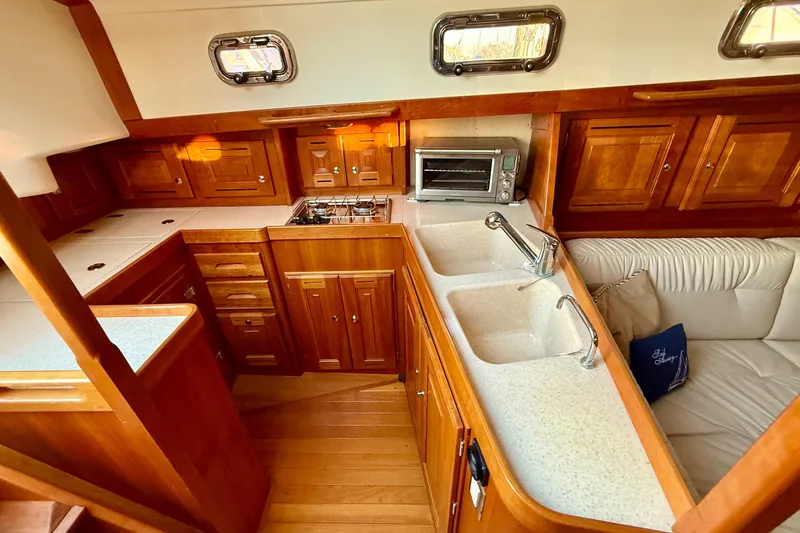 Tangaroa Yacht Photos Pics Luxurious Tartan 4000 yacht interior with wooden cabinetry, dual sinks, and cozy seating, 2015 model.