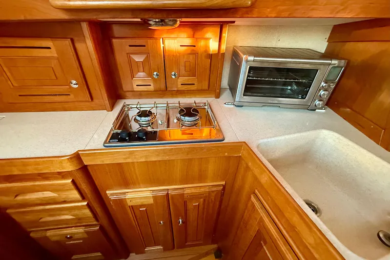 Tangaroa Yacht Photos Pics Wooden kitchen interior of 2015 Tartan 4000 with stove, oven, and sink.