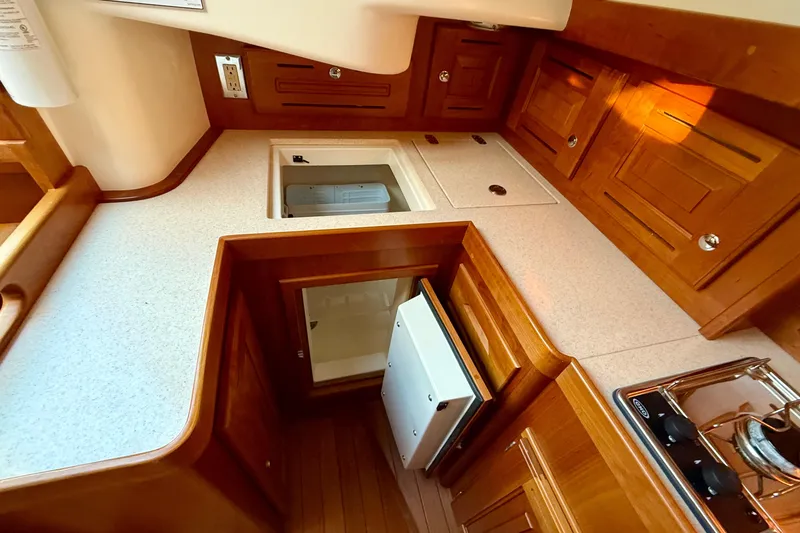 Tangaroa Yacht Photos Pics Compact kitchen area in a 2015 Tartan 4000 yacht with wooden cabinetry.