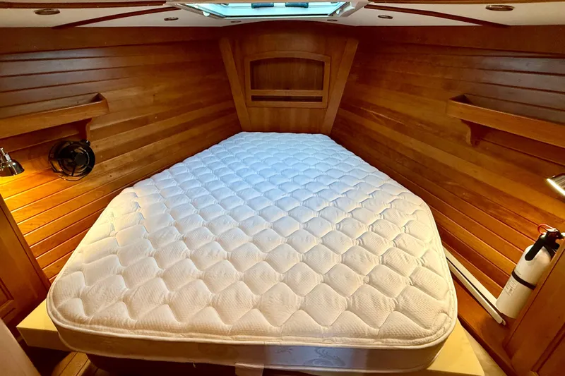 Tangaroa Yacht Photos Pics Cozy cabin interior of 2015 Tartan 4000 yacht with wooden walls and comfortable bed.