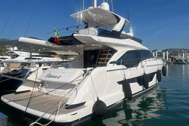  Yacht Photos Pics 2025 Ferretti Yachts 670 docked in a marina, showcasing sleek design and luxury features.