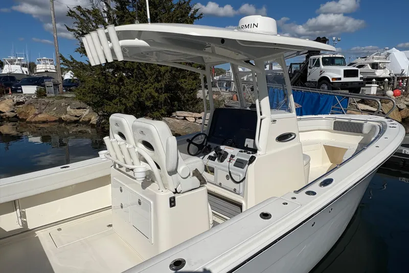  Yacht Photos Pics 2022 Cobia 280 Center Console boat docked, featuring dual seats and advanced navigation equipment.