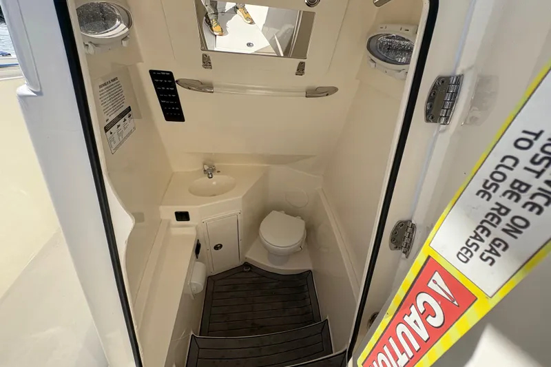  Yacht Photos Pics 2022 Cobia 280 Center Console boat interior with compact bathroom and sink.