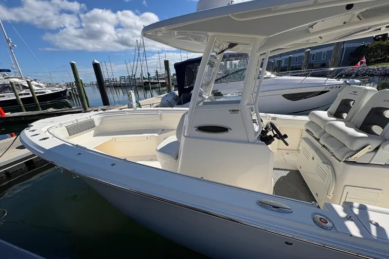  Yacht Photos Pics 2022 Cobia 280 Center Console boat docked at marina under blue sky.