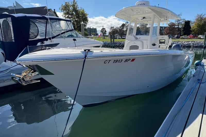  Yacht Photos Pics 2022 Cobia 280 Center Console boat docked in a marina under clear skies.