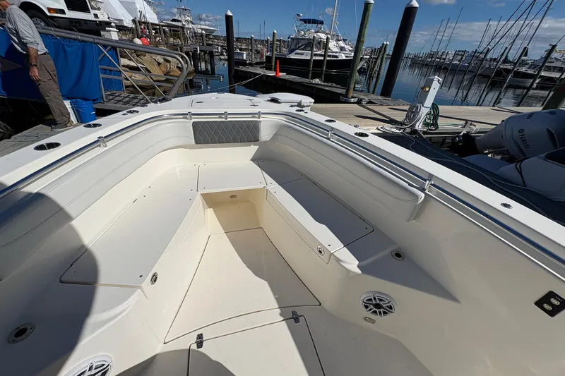  Yacht Photos Pics 2022 Cobia 280 Center Console boat interior at marina, featuring spacious seating and storage.