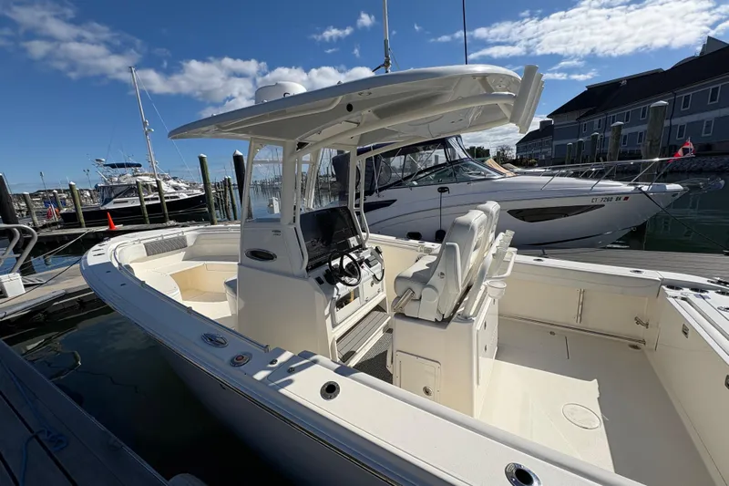  Yacht Photos Pics 2022 Cobia 280 Center Console boat docked at marina under clear blue sky.
