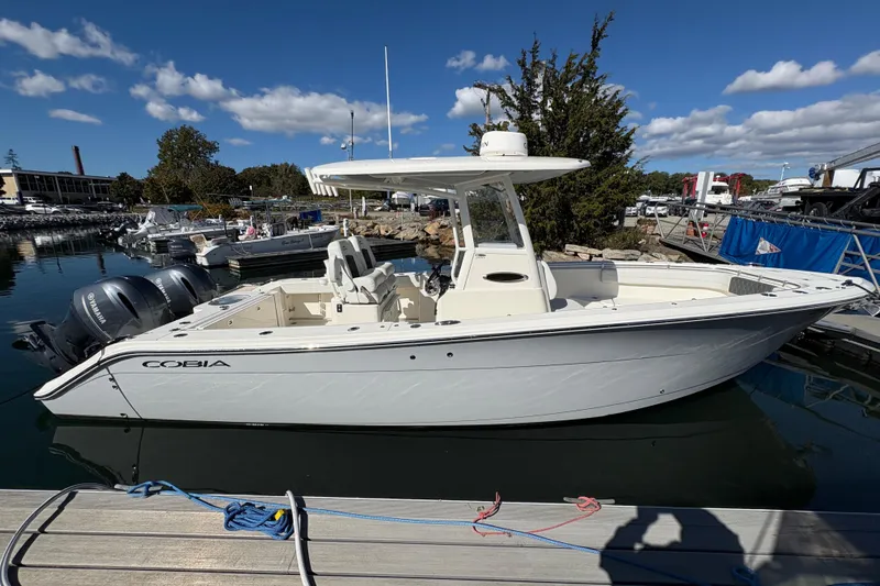  Yacht Photos Pics 2022 Cobia 280 Center Console boat docked, featuring twin Yamaha engines under a clear blue sky.