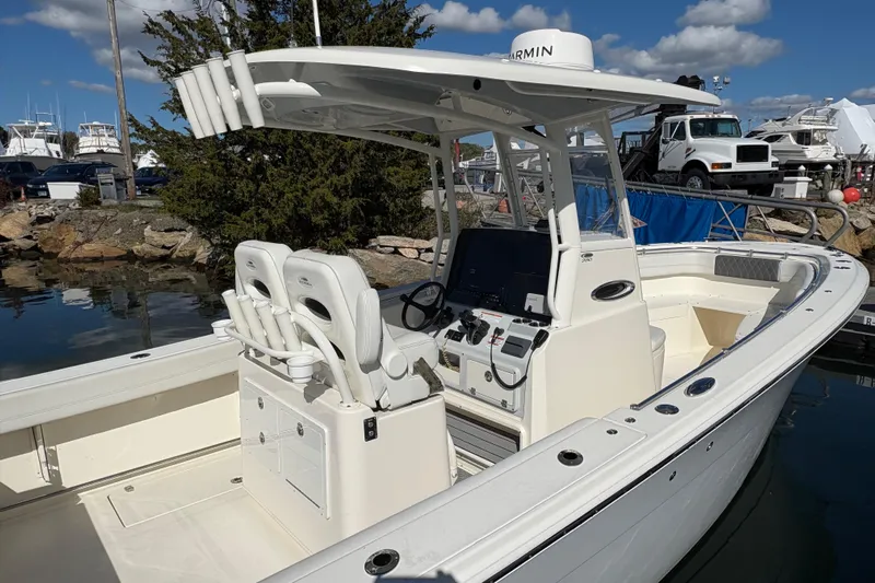  Yacht Photos Pics 2022 Cobia 280 Center Console boat docked, featuring dual seats and advanced navigation equipment.