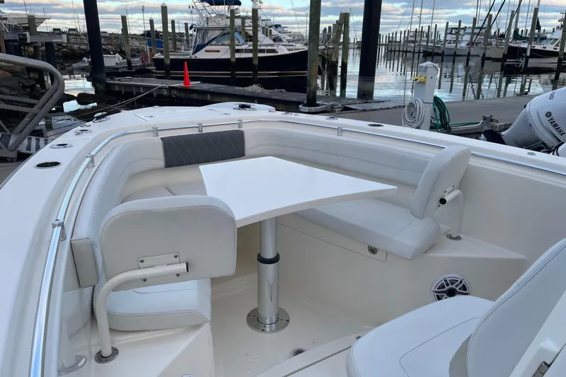 Yacht Photos Pics 2022 Cobia 280 Center Console boat with seating and table at marina.
