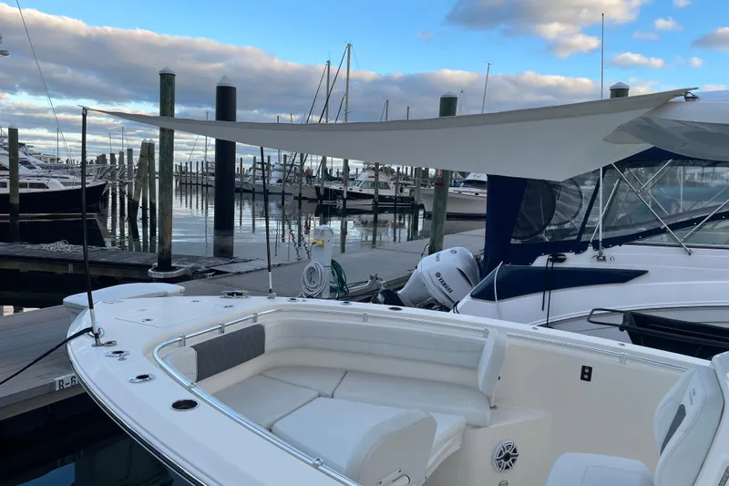  Yacht Photos Pics 2022 Cobia 280 Center Console boat docked with sunshade, marina background.
