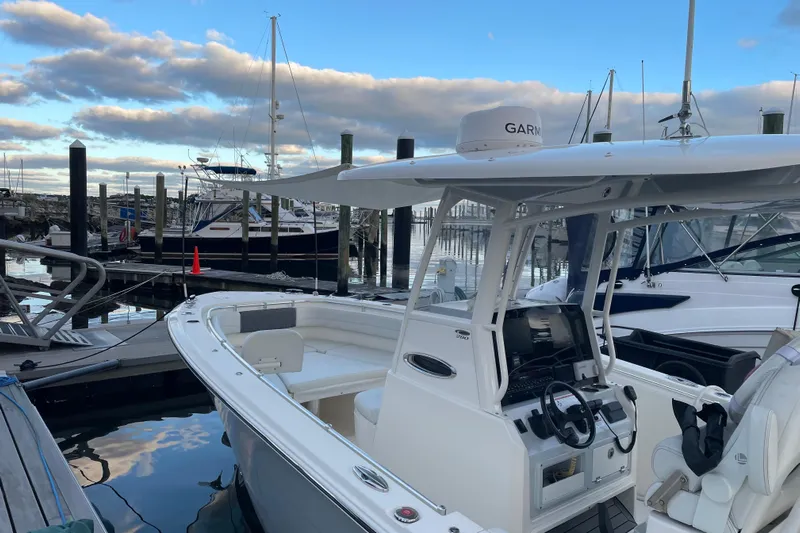  Yacht Photos Pics 2022 Cobia 280 Center Console boat docked at marina under cloudy sky.