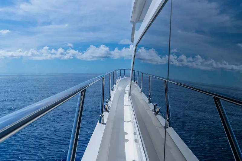  Yacht Photos Pics Luxurious 2019 Regency P65 yacht cruising on open ocean under clear blue skies.