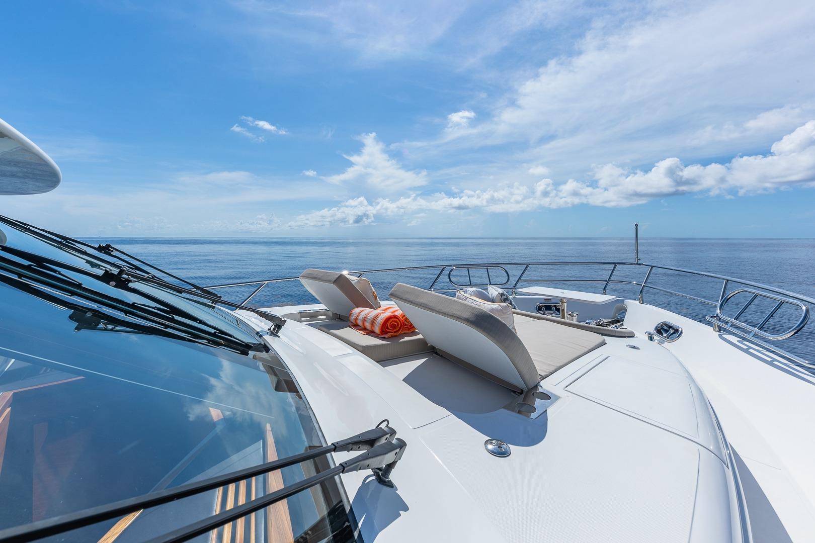 Luxurious 2019 Regency P65 yacht deck with sun loungers and ocean view.