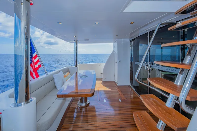  Yacht Photos Pics Luxurious 2019 Regency P65 yacht deck with seating, table, and ocean view.