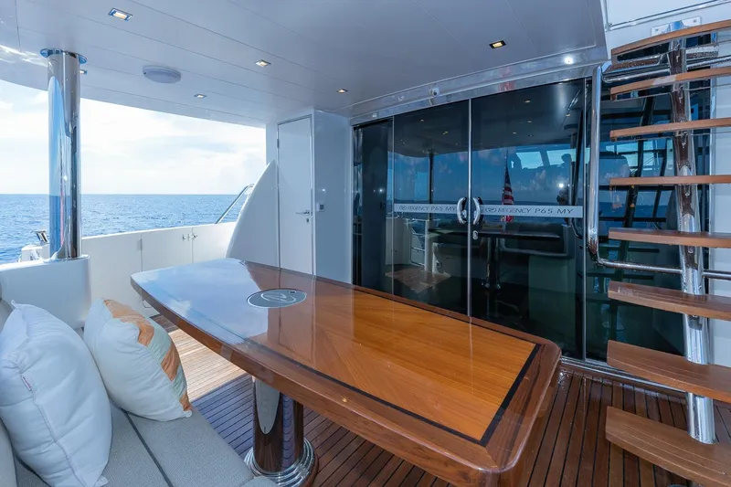  Yacht Photos Pics Luxurious Regency P65 yacht deck with wooden table, stairs, and ocean view, 2019 model.