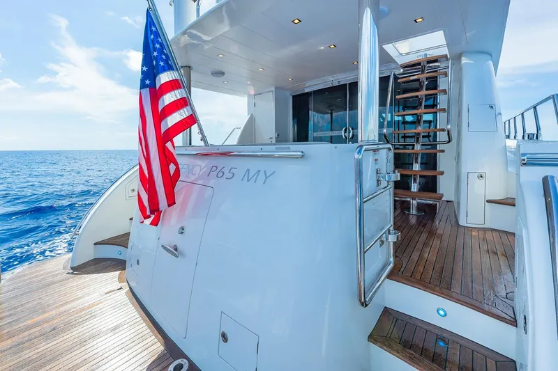  Yacht Photos Pics Luxury 2019 Regency P65 yacht with American flag, wooden deck, and ocean view.