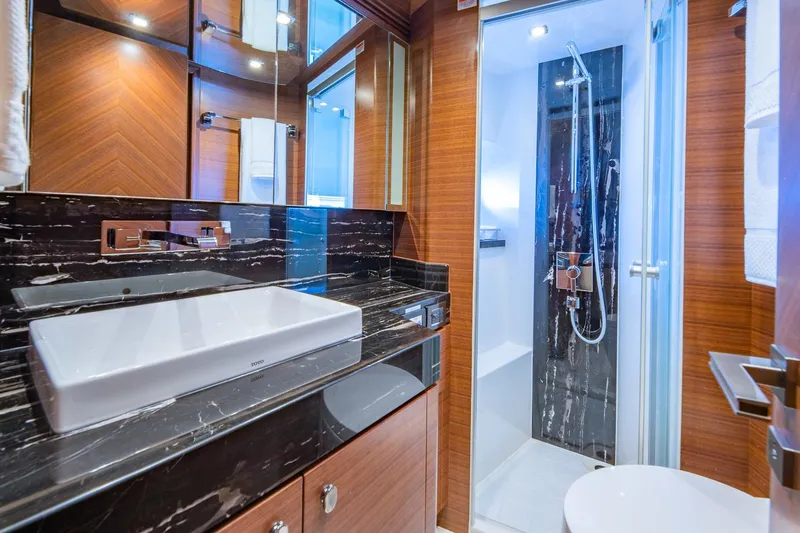  Yacht Photos Pics Luxurious bathroom in 2019 Regency P65 yacht with modern fixtures and elegant wood paneling.