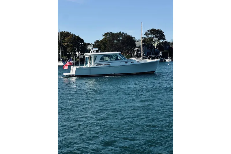 2021 Back Cove 37 Yacht Photos Pics 2021 Back Cove 37 boat cruising on a calm blue waterway with trees in the background.