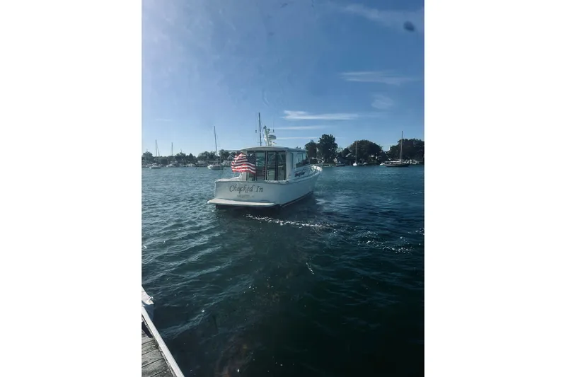 2021 Back Cove 37 Yacht Photos Pics Back Cove 37 boat from 2021 on water, American flag displayed, clear sky.
