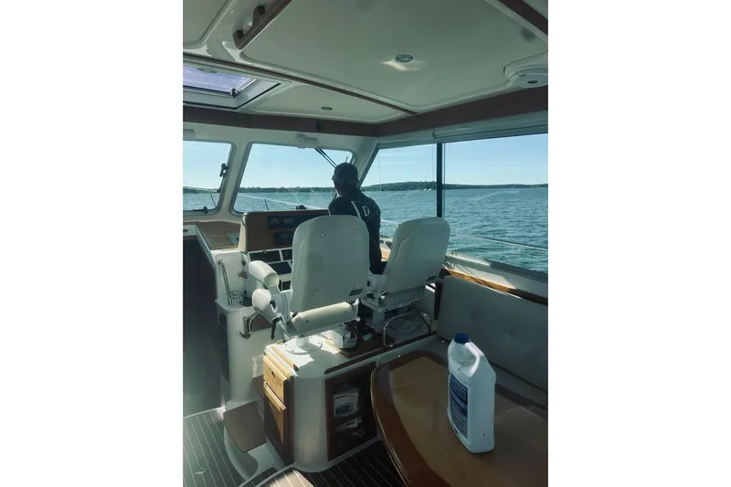 2021 Back Cove 37 Yacht Photos Pics Interior view of 2021 Back Cove 37 boat with person steering on open water.