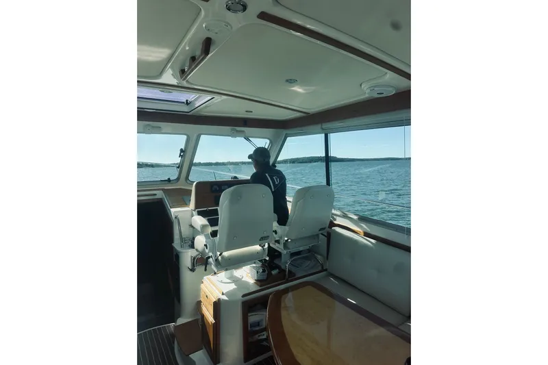 2021 Back Cove 37 Yacht Photos Pics Interior view of 2021 Back Cove 37 boat with person navigating on open water.