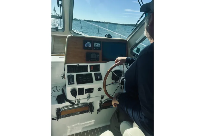 2021 Back Cove 37 Yacht Photos Pics Person steering a 2021 Back Cove 37 boat on open water, view of control panel.