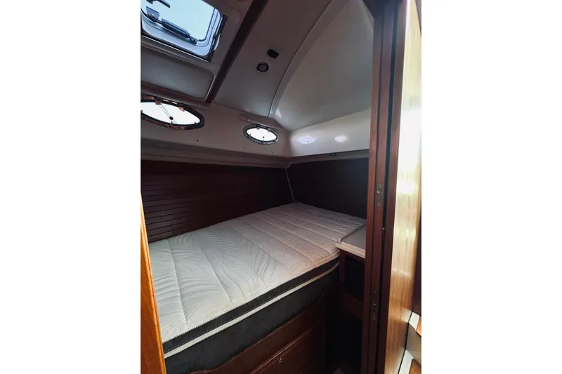 2021 Back Cove 37 Yacht Photos Pics 2021 Back Cove 37 cabin interior with bed, wooden accents, and porthole windows.
