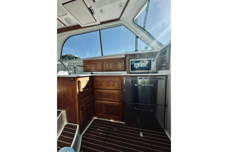 2021 Back Cove 37 Yacht Photos Pics 2021 Back Cove 37 yacht interior with wooden cabinetry and stainless steel appliances.