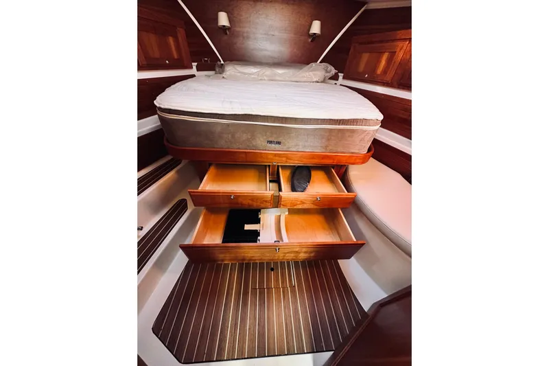 2021 Back Cove 37 Yacht Photos Pics Interior of 2021 Back Cove 37 yacht with bed and open wooden drawers.