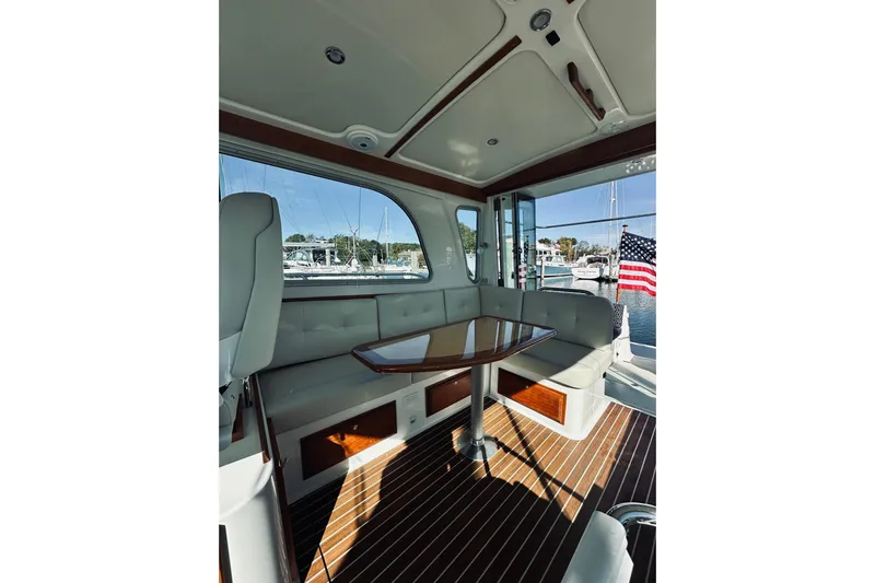 2021 Back Cove 37 Yacht Photos Pics Interior of 2021 Back Cove 37 yacht with seating and table, docked at marina.