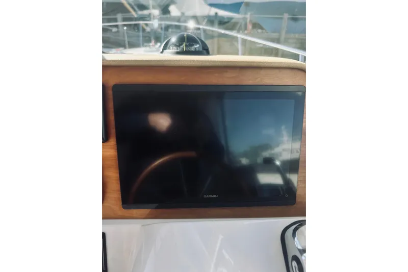 2021 Back Cove 37 Yacht Photos Pics Garmin display on 2021 Back Cove 37 yacht dashboard, featuring wooden paneling.