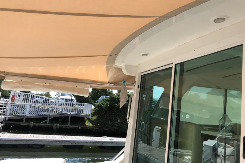 2021 Back Cove 37 Yacht Photos Pics 2021 Back Cove 37 yacht with beige canopy and glass doors at a dock.