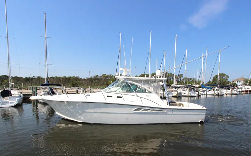Duke Yacht Photos Pics 2005 Rampage 35 Express boat docked in a marina with sailboats.