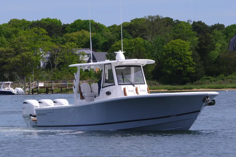 Storm Gray Yacht Photos Pics 2025 Regulator 35 boat cruising on a calm lake with lush green trees in the background.