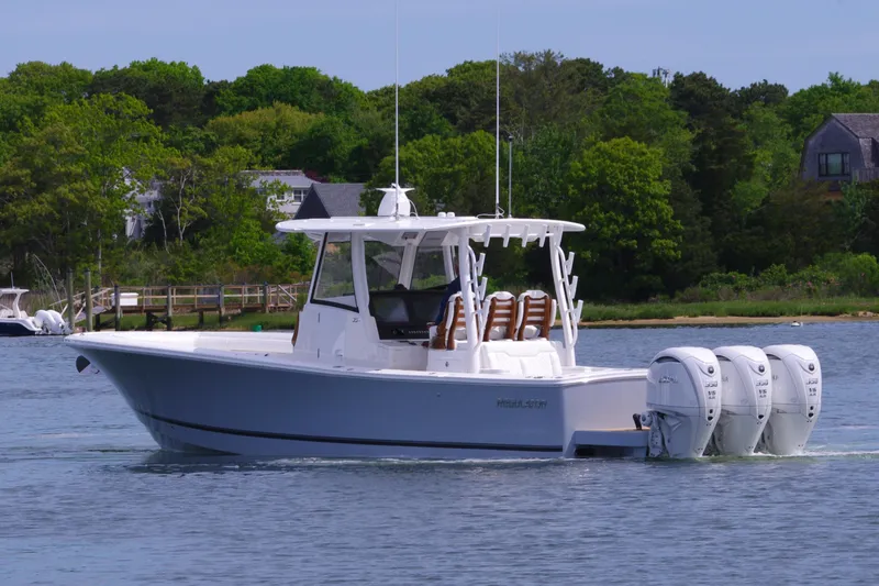 Storm Gray Yacht Photos Pics 2025 Regulator 35 boat with triple engines on a calm lake.