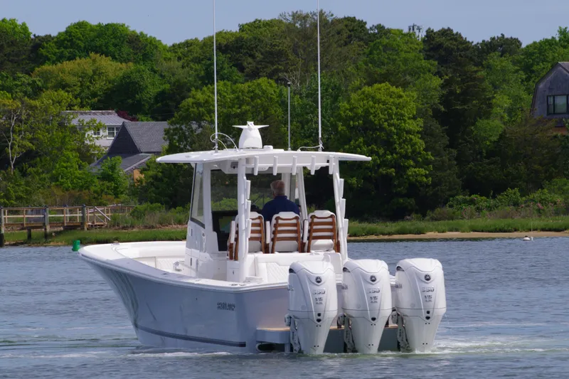 Storm Gray Yacht Photos Pics 2025 Regulator 35 boat with triple outboard engines on a calm lake.