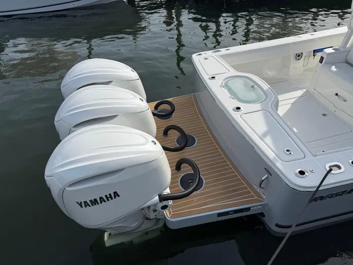 Storm Gray Yacht Photos Pics 2025 Regulator 35 boat with triple Yamaha outboard engines, docked on calm water.