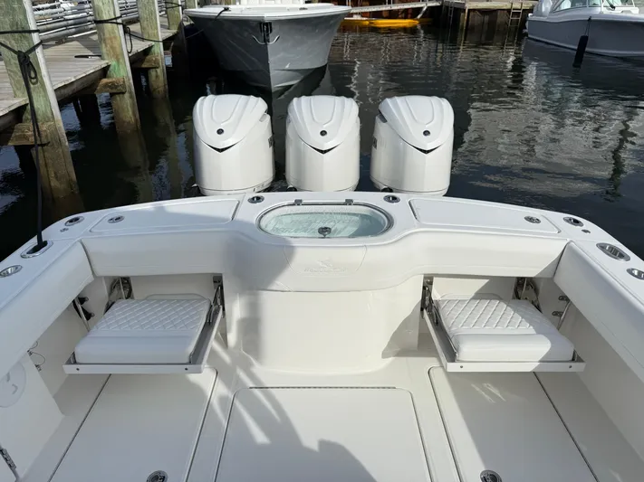 Storm Gray Yacht Photos Pics 2025 Regulator 35 boat with triple engines and seating, docked in a marina.