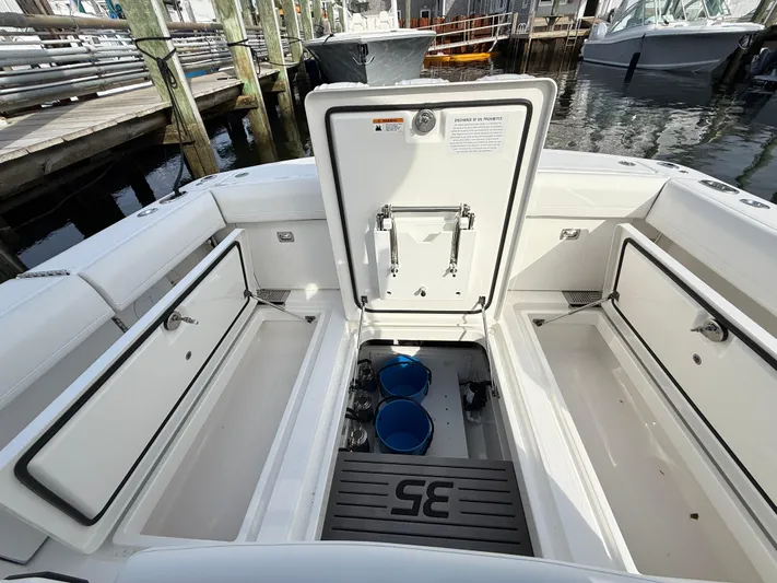 Storm Gray Yacht Photos Pics 2025 Regulator 35 boat interior with open storage compartments at a marina.