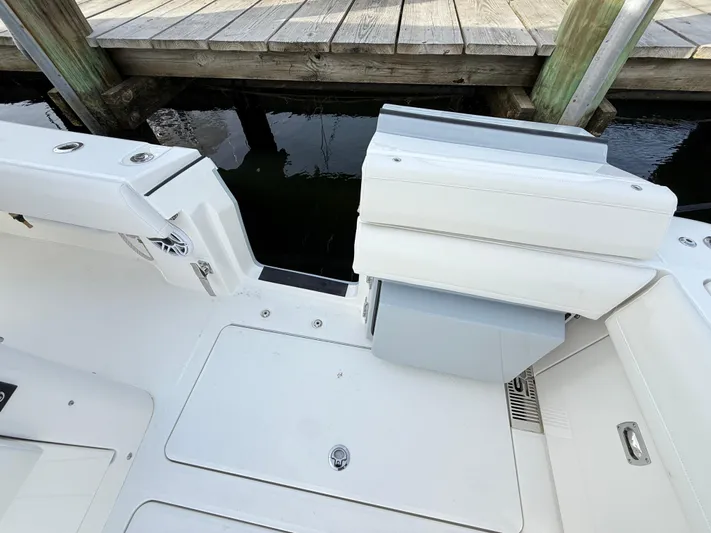 Storm Gray Yacht Photos Pics 2025 Regulator 35 boat interior, featuring sleek white seating and deck near a wooden dock.