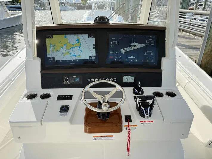 Storm Gray Yacht Photos Pics 2025 Regulator 35 boat dashboard with dual navigation screens and steering wheel.