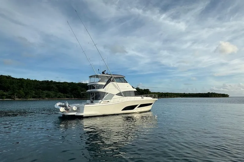 Yacht Photos Pics 2021 Riviera 50 Sports Motor Yacht on calm water under a cloudy sky.
